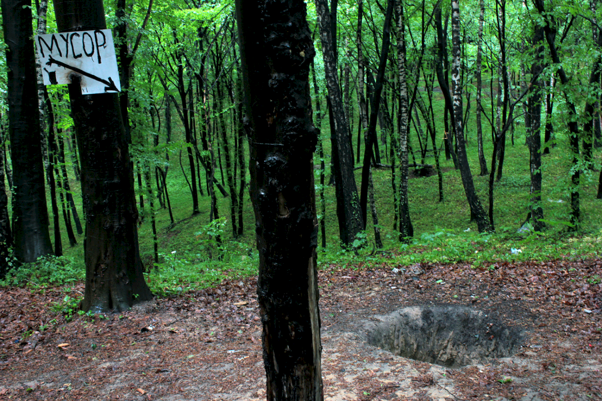 Schätzungsweise 90.–100.000 Menschen wurden im Wald von Lisinichi in der Nähe von Lviv/Ukraine erschossen, verbrannt und begraben. Das Schild mit der Aufschrift "Müll" weist auf ein Loch hin, in das Spaziergänger ihren Abfall entsorgen