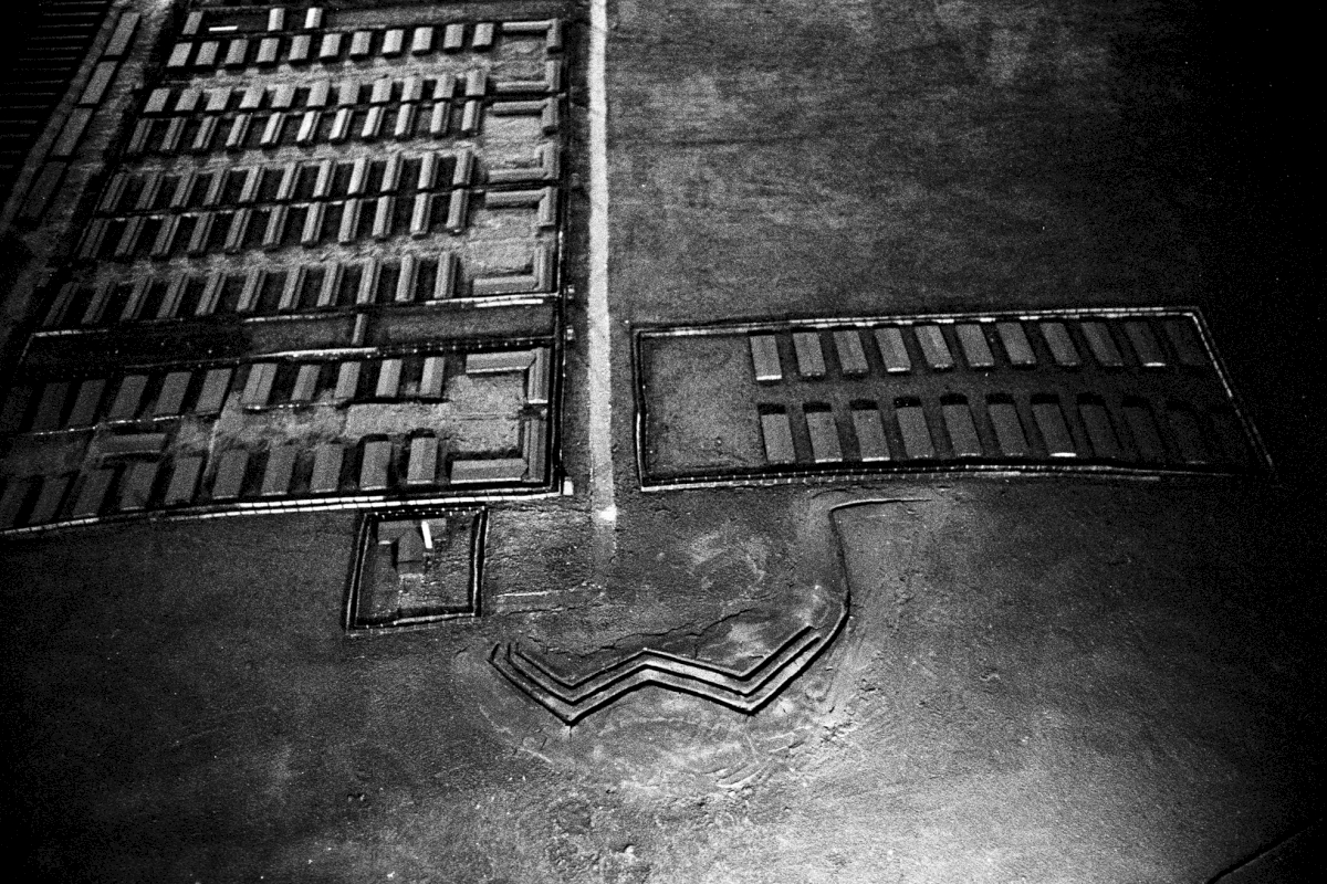 Ein Miniaturmodell des nördlichen Lagers mit Baracken und Krematorium. Die Risse symbolisieren die Erschießungsgräben, in denen am 3. November 1943 bei der "Aktion Erntefest" etwa 18.000 Menschen ermordet wurden.