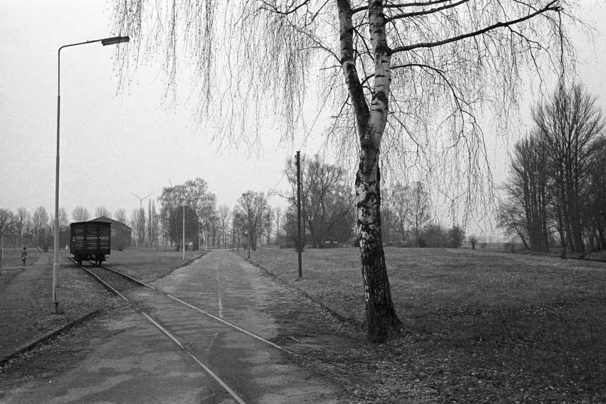 Reconstructed track system at the former camp railway station with a historical railroad car